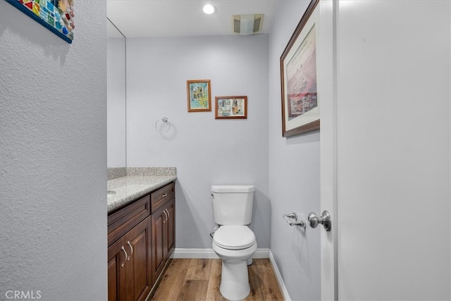 bathroom with vanity, wood-type flooring, and toilet