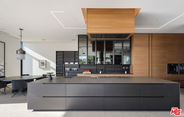 kitchen with light tile patterned flooring, hanging light fixtures, and sink