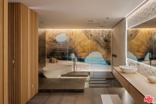 bathroom with vanity, tile walls, and a bath