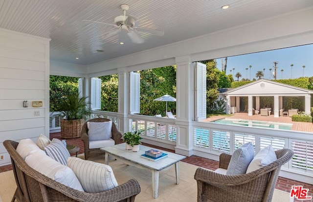 sunroom / solarium featuring ceiling fan