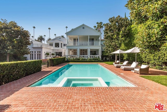 view of swimming pool with an in ground hot tub and a patio area