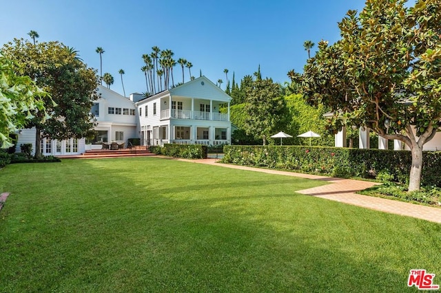 exterior space featuring a lawn and a balcony