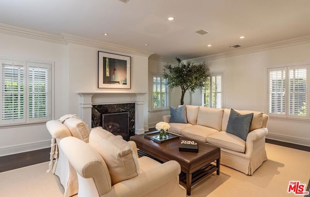 living room featuring a wealth of natural light, a high end fireplace, light hardwood / wood-style flooring, and ornamental molding