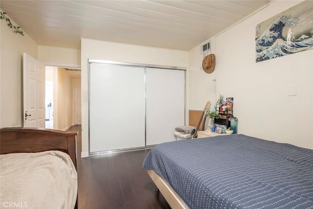 bedroom with a closet and dark hardwood / wood-style flooring