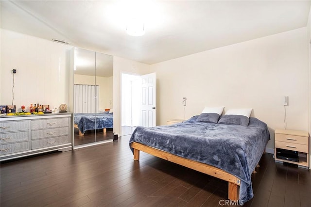 bedroom with dark hardwood / wood-style flooring