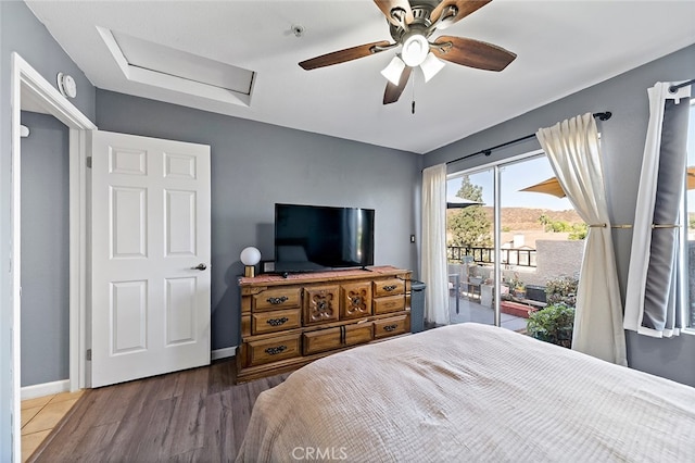 bedroom featuring access to exterior, wood-type flooring, and ceiling fan