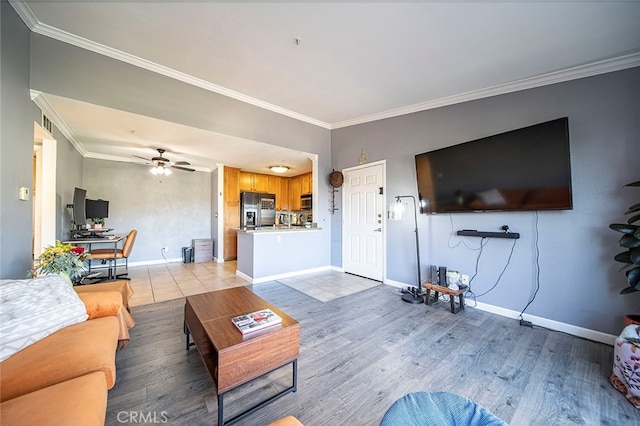 living room featuring ceiling fan, ornamental molding, and light hardwood / wood-style flooring