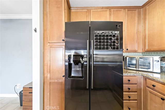 kitchen with decorative backsplash, black refrigerator with ice dispenser, ornamental molding, light tile patterned floors, and light stone counters