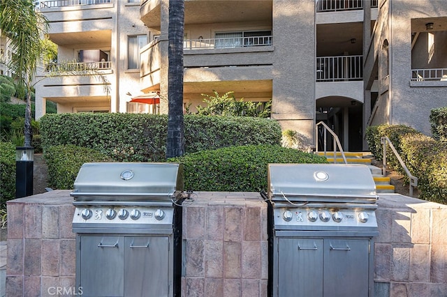 view of patio featuring a balcony, exterior kitchen, and area for grilling