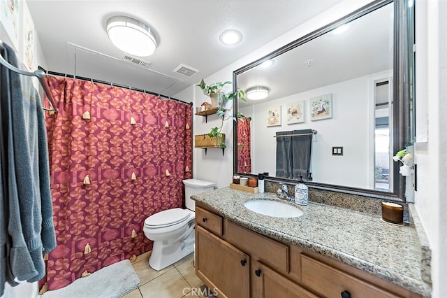 bathroom with toilet, vanity, and tile patterned flooring