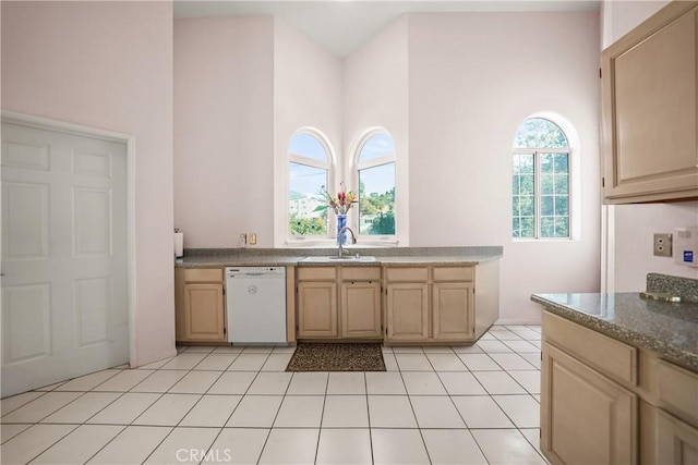 kitchen featuring sink, dishwasher, light brown cabinetry, and light tile patterned floors