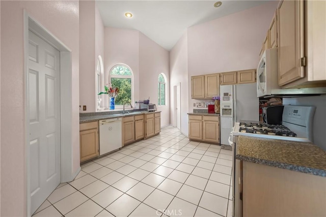 kitchen with light brown cabinets, sink, light tile patterned flooring, white appliances, and high vaulted ceiling