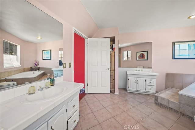 bathroom with tiled bath, tile patterned floors, and vanity