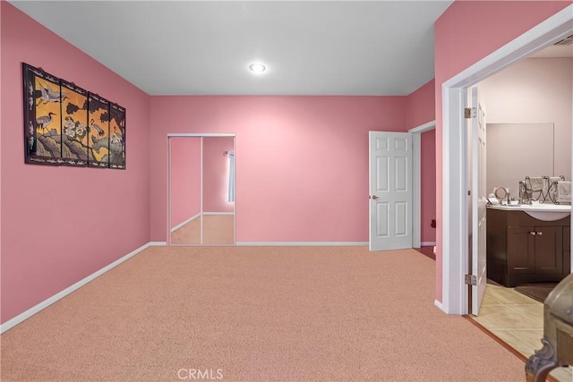 bedroom with light colored carpet and connected bathroom