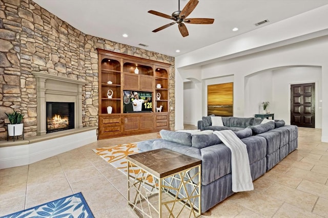 living room featuring ceiling fan, light tile patterned flooring, built in features, and a fireplace