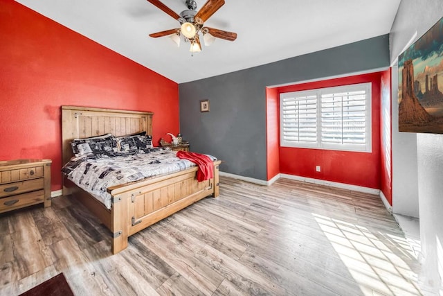 bedroom with lofted ceiling, hardwood / wood-style flooring, and ceiling fan