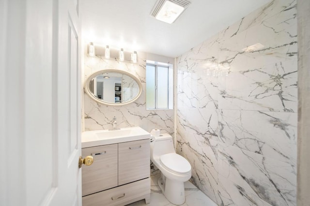 bathroom featuring vanity, tile walls, and toilet