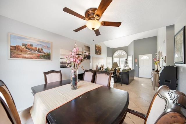 tiled dining space with ceiling fan and vaulted ceiling