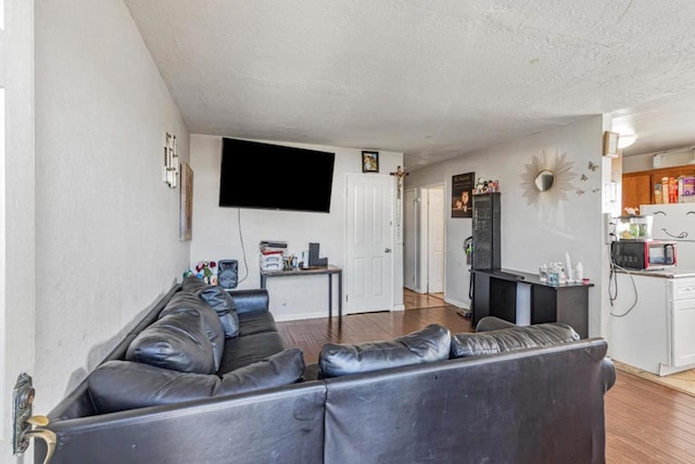 living room featuring a textured ceiling and light wood-type flooring