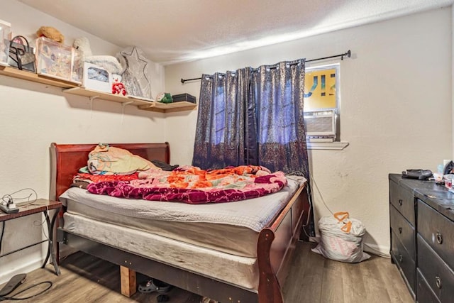 bedroom with hardwood / wood-style floors and cooling unit