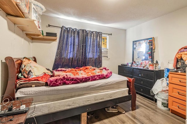 bedroom featuring light hardwood / wood-style flooring and a textured ceiling