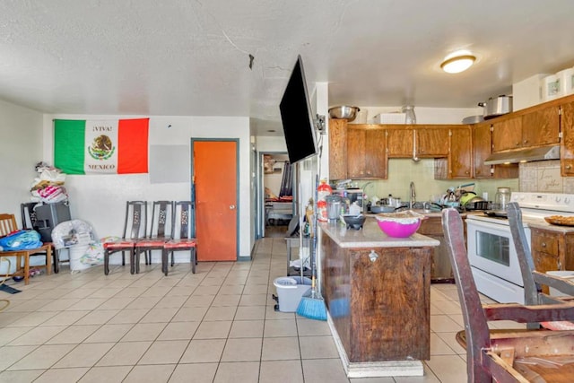 kitchen with white range with electric cooktop, sink, light tile patterned floors, and a textured ceiling