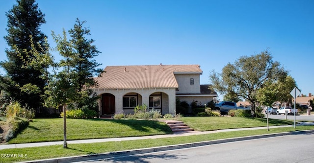 mediterranean / spanish-style home featuring a front lawn and a porch