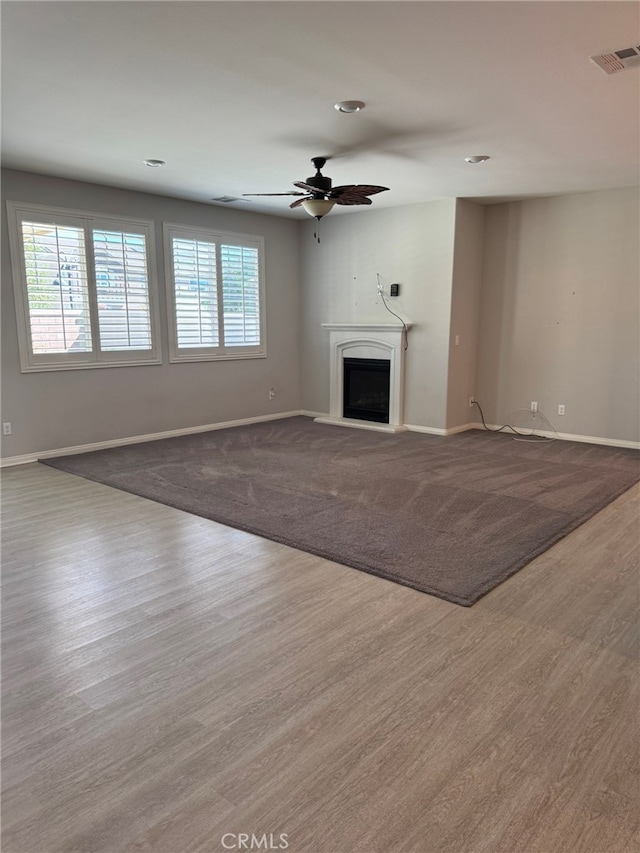 unfurnished living room featuring wood-type flooring and ceiling fan