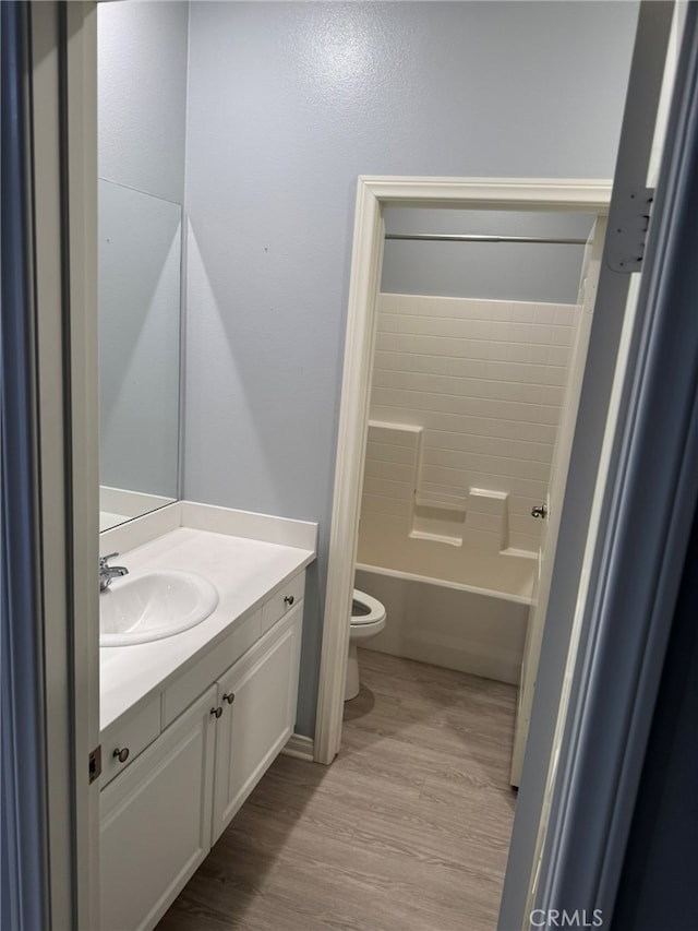 full bathroom featuring shower / tub combination, hardwood / wood-style floors, vanity, and toilet