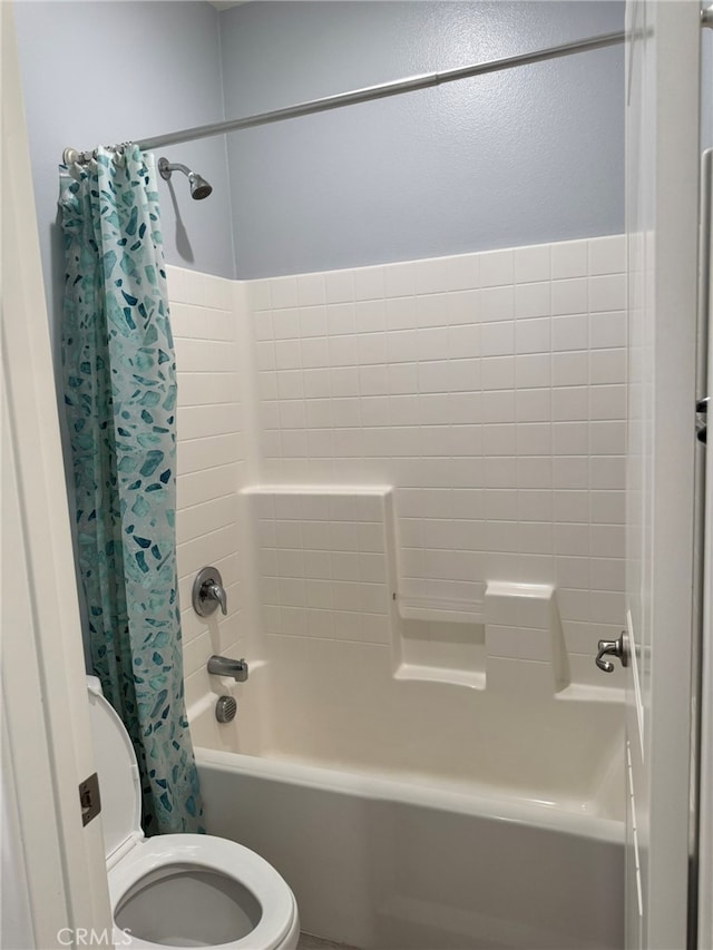 bathroom with shower / bath combination with curtain and toilet