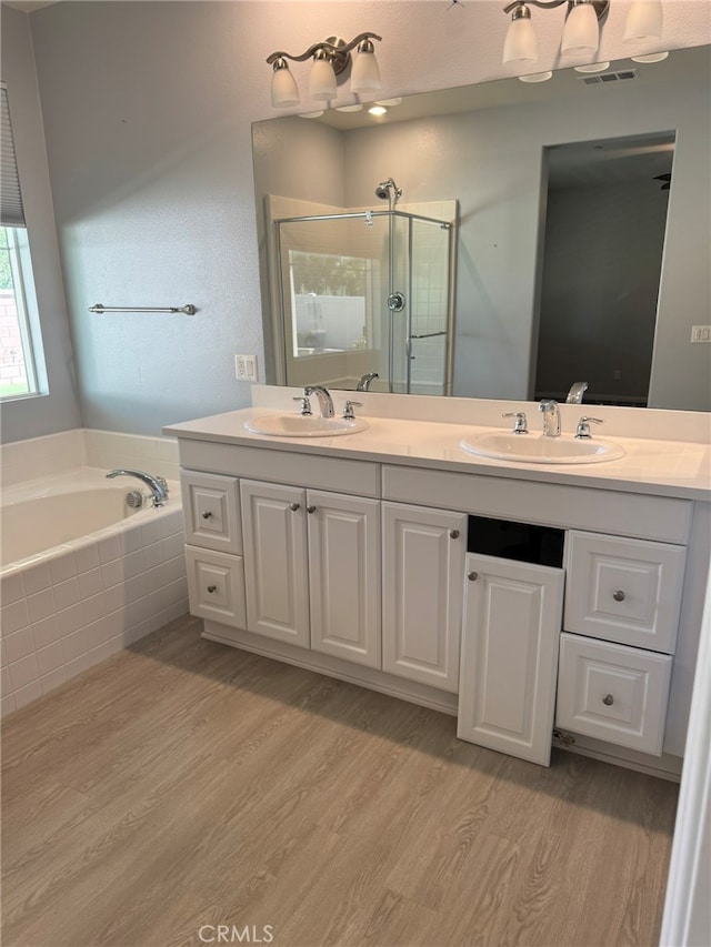 bathroom featuring independent shower and bath, vanity, and hardwood / wood-style flooring