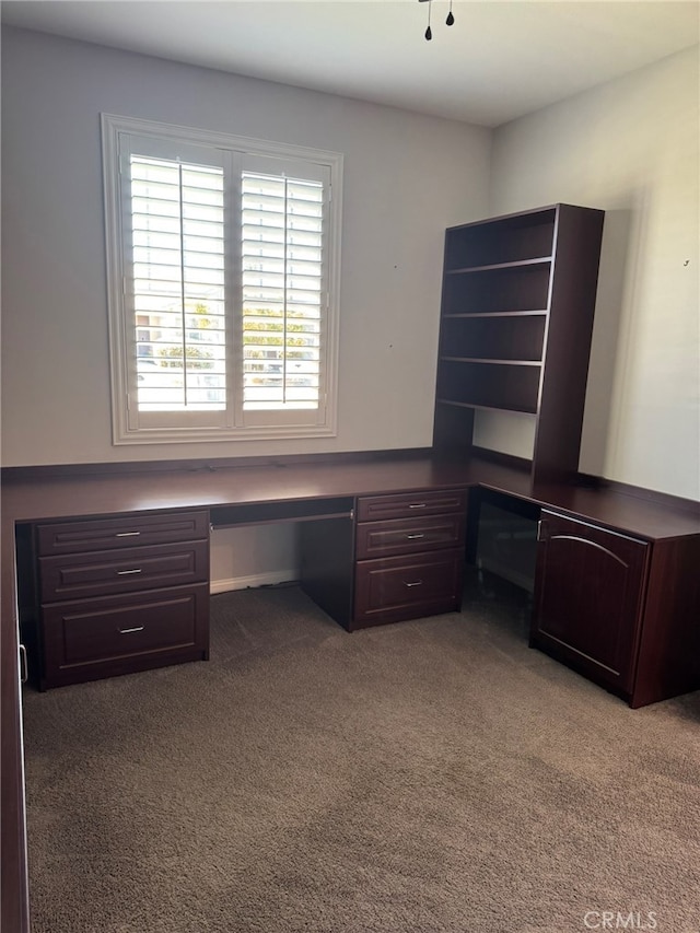 unfurnished office featuring light carpet and built in desk