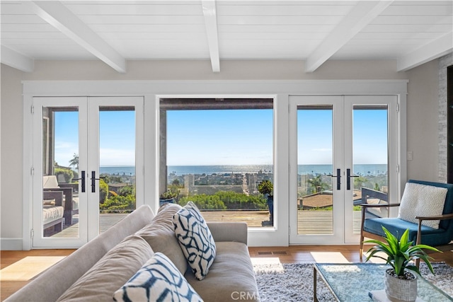 sunroom featuring beam ceiling, french doors, and a healthy amount of sunlight