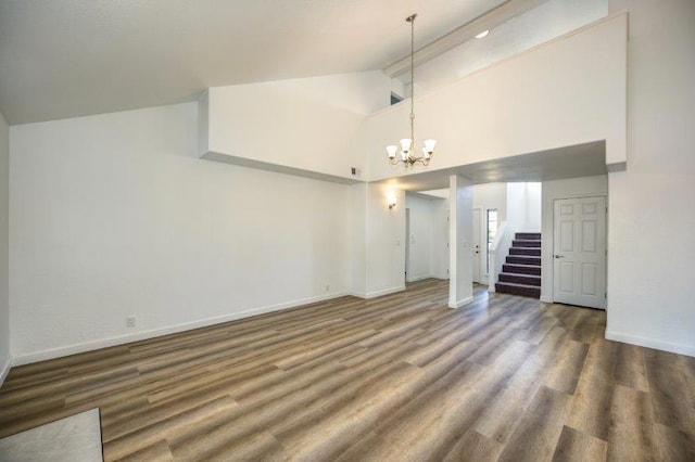 unfurnished living room featuring an inviting chandelier, dark hardwood / wood-style floors, and high vaulted ceiling