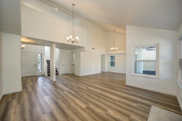 unfurnished living room with a chandelier, hardwood / wood-style flooring, and high vaulted ceiling