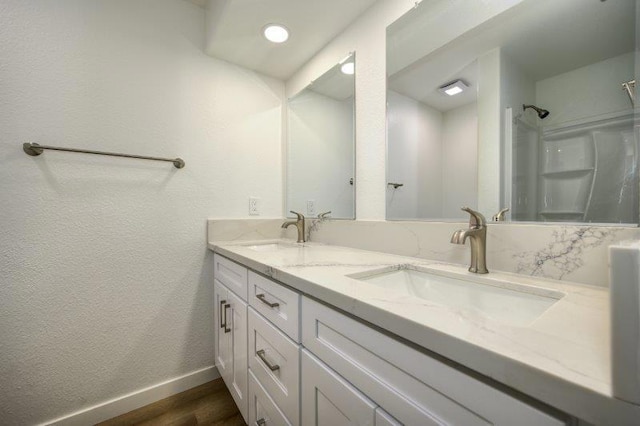 bathroom with vanity, walk in shower, and wood-type flooring