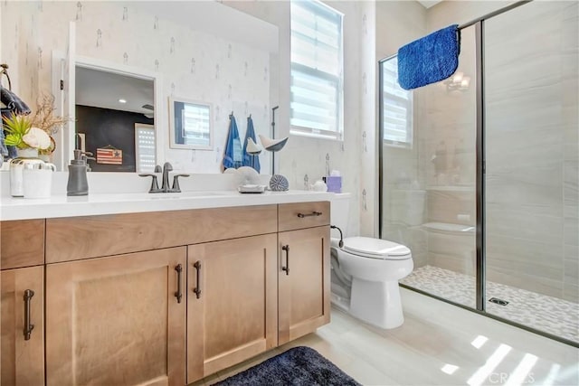 bathroom featuring a shower with shower door, toilet, and vanity