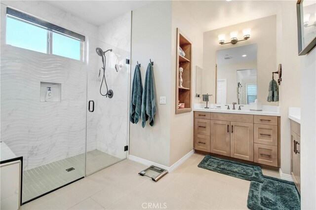 bathroom featuring a shower with shower door, vanity, and built in shelves