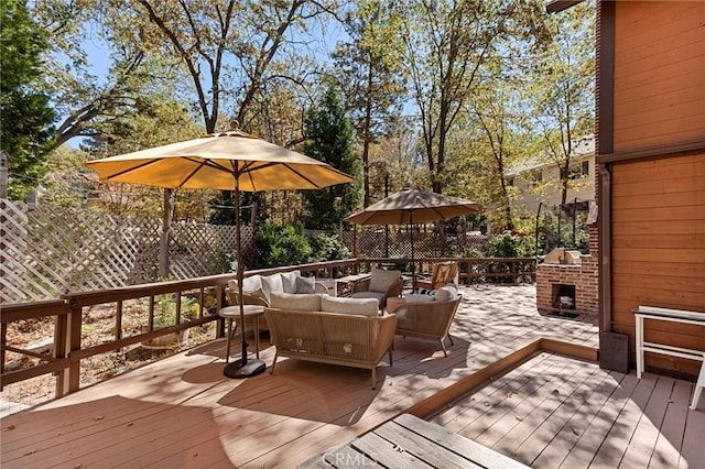 deck with an outdoor living space with a fireplace