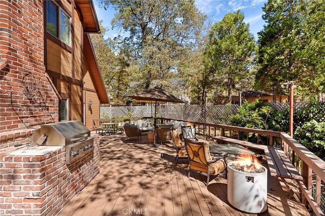 view of patio / terrace featuring a deck, a fire pit, and area for grilling