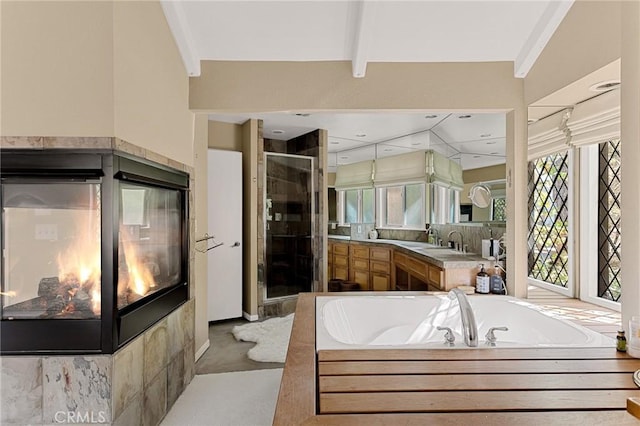 bathroom with vanity, lofted ceiling with beams, and shower with separate bathtub