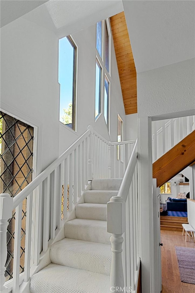 stairway featuring hardwood / wood-style flooring, lofted ceiling, and wood ceiling