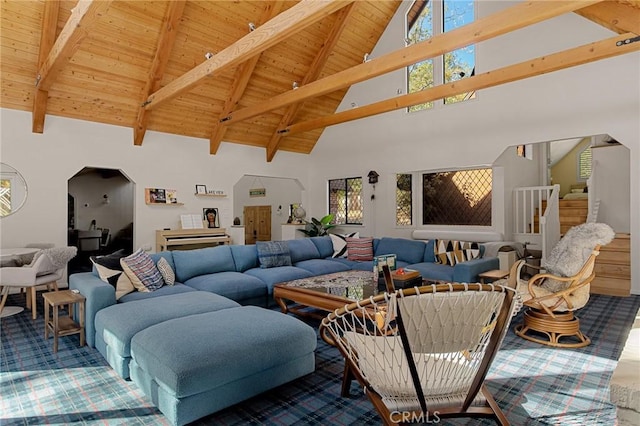 carpeted living room featuring high vaulted ceiling, a healthy amount of sunlight, beamed ceiling, and wooden ceiling