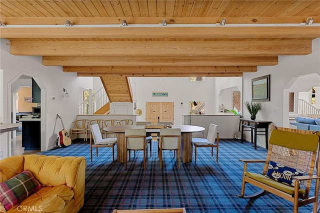 dining room featuring wooden ceiling, beamed ceiling, and carpet flooring