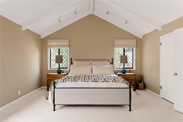 carpeted bedroom featuring lofted ceiling with beams, track lighting, and multiple windows