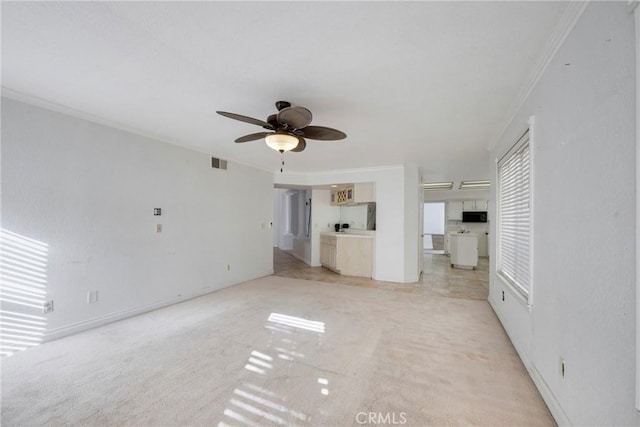 unfurnished living room with ornamental molding, light carpet, and ceiling fan