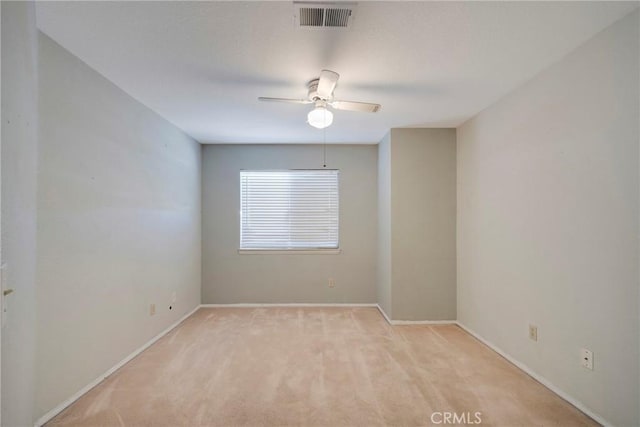 empty room featuring light carpet, baseboards, visible vents, and a ceiling fan