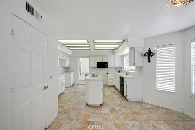 kitchen with sink, white cabinetry, a textured ceiling, a kitchen island, and black appliances