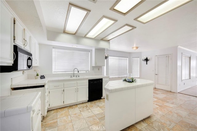 kitchen with tile counters, a center island, white cabinets, and black appliances