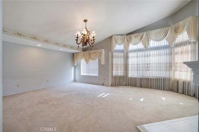 carpeted spare room with vaulted ceiling and a notable chandelier